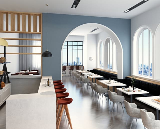 アーチ開口と大きな窓が特徴の明るいカフェ内装。白と淡いブルーを基調に、カウンター席とテーブル席を配置した洗練された店舗デザイン