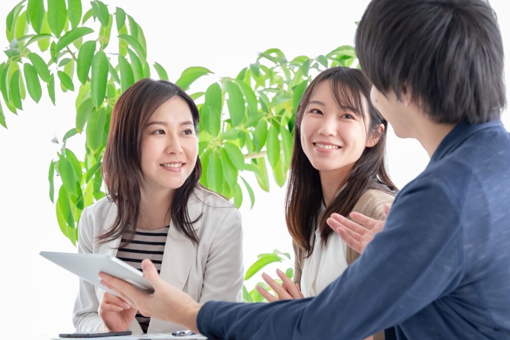 タブレットを使いながら、スタッフと顧客が打ち合わせや相談をしている様子
