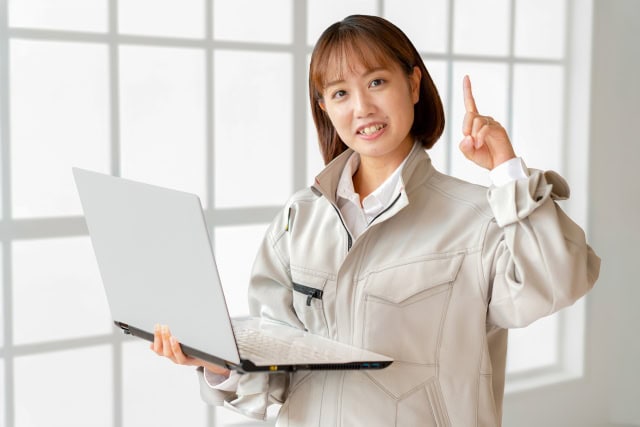 ノートパソコンを持ちながら、内装工事や店舗づくりのポイントを説明しているスタッフの様子