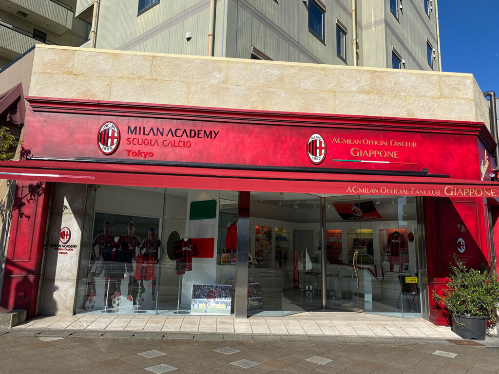 赤を基調とした外観デザインが特徴的な、スポーツブランド公式ショップの店舗外観