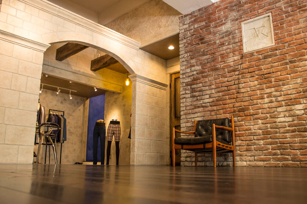 レンガ壁とアーチ構造を組み合わせた、重厚感と開放感のあるアパレル店舗内装デザイン