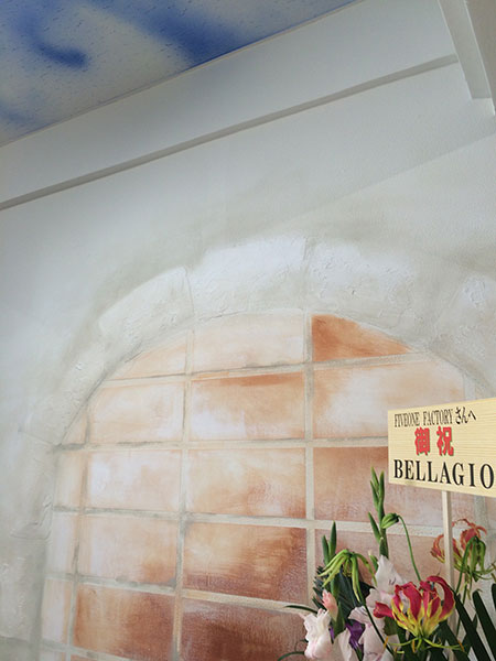 アーチ状の塗り壁とタイル調仕上げを組み合わせた、店舗内装の壁面デザイン