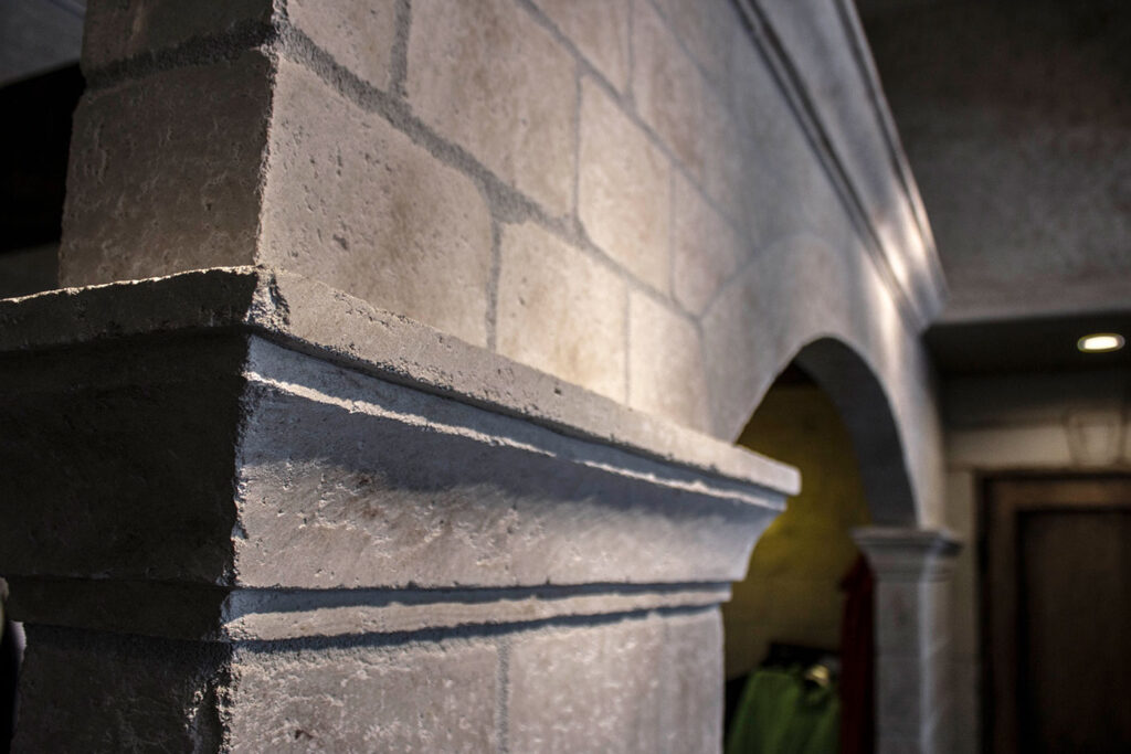 アーチ形状と石調仕上げを組み合わせた、重厚感のある店舗内装ディテール