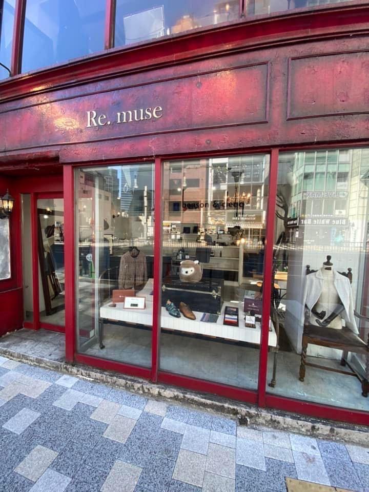 赤いフレームとエイジング塗装の外観に『Re. muse』のサインが入った路面店。大きなガラス越しにアパレルや雑貨がディスプレイされている。